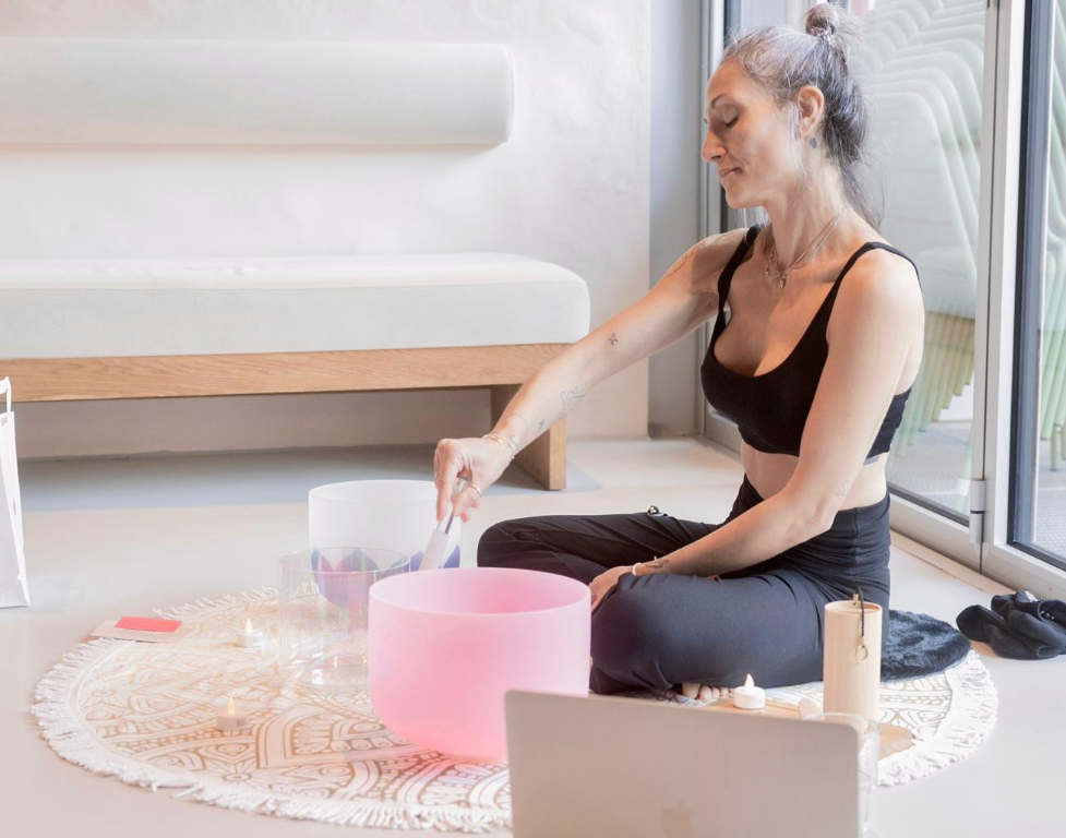 woman playing crystal singing bowls